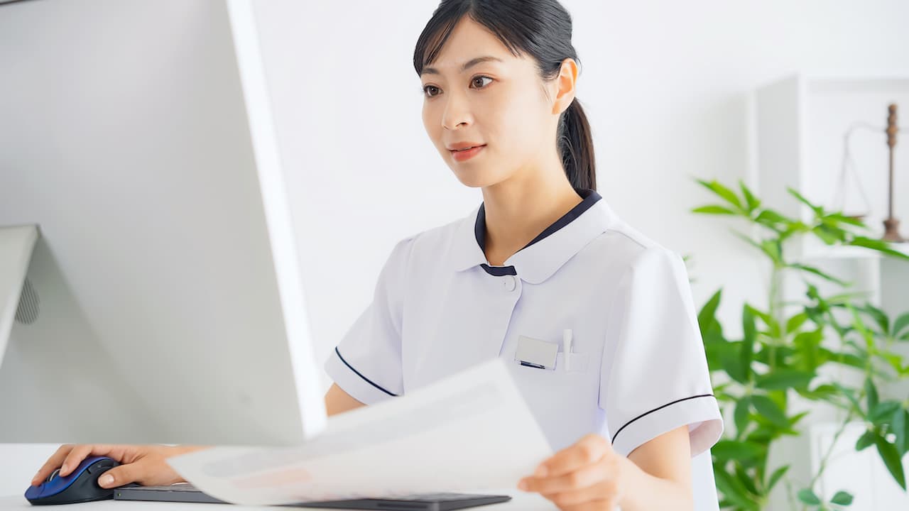 Woman in a lab coat working on patient billing and accounting records